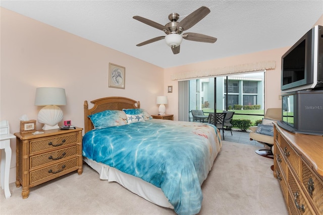 bedroom featuring access to outside, ceiling fan, a textured ceiling, and light colored carpet