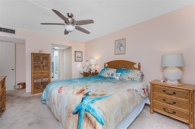 bedroom featuring a closet, visible vents, light carpet, ceiling fan, and a textured ceiling