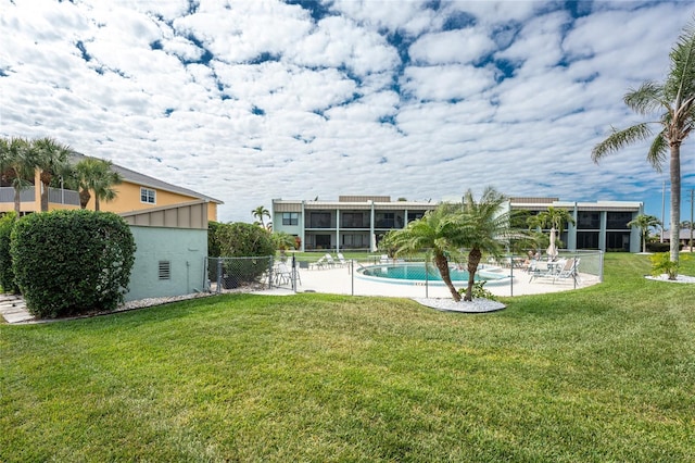view of yard featuring an outdoor pool, a patio, and fence