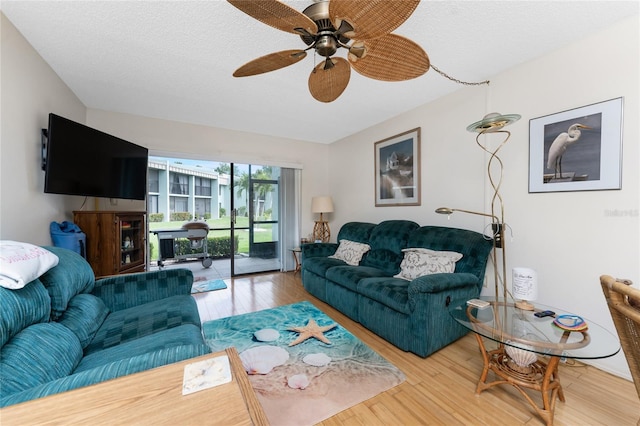 living room featuring a textured ceiling, wood finished floors, and a ceiling fan