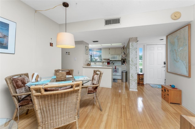 dining room featuring light wood-type flooring and visible vents