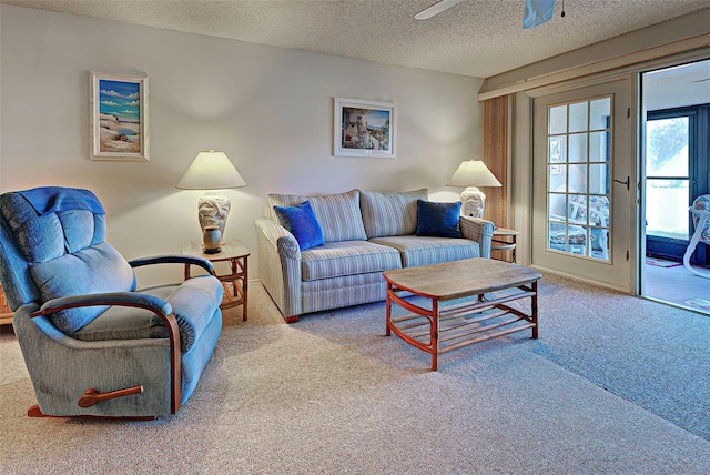 living area with carpet, a ceiling fan, and a textured ceiling