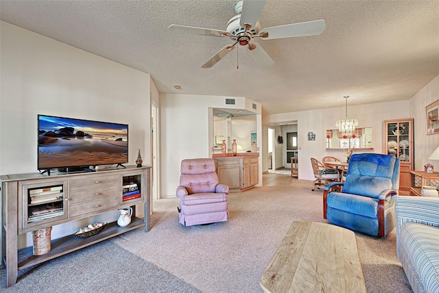 carpeted living room featuring visible vents, a textured ceiling, and ceiling fan with notable chandelier