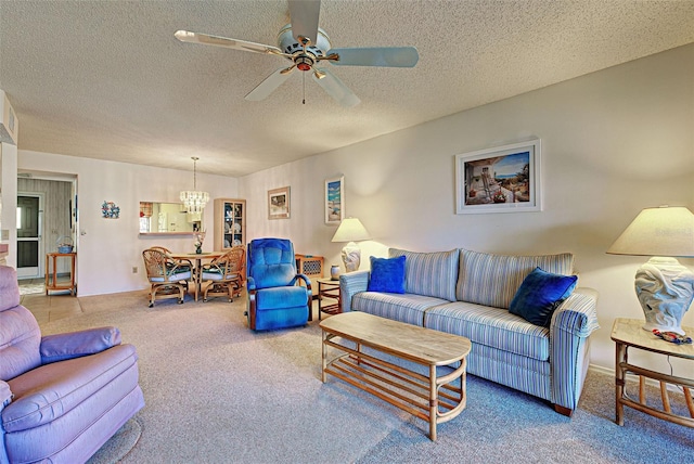 living area featuring carpet, a textured ceiling, and ceiling fan with notable chandelier