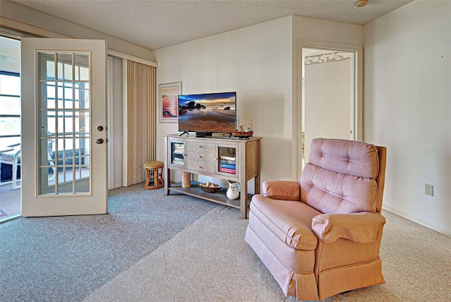 sitting room featuring carpet floors and a textured ceiling