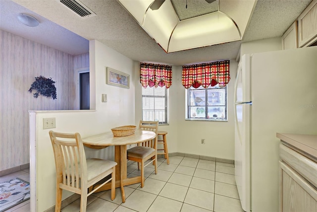 dining room with light tile patterned floors, a textured ceiling, and visible vents