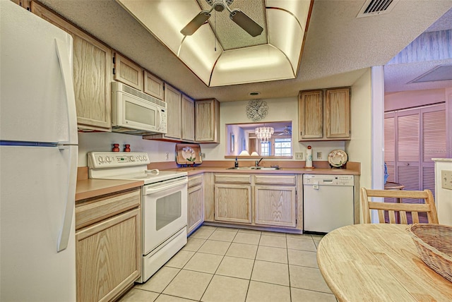 kitchen with light tile patterned floors, white appliances, a sink, visible vents, and light countertops