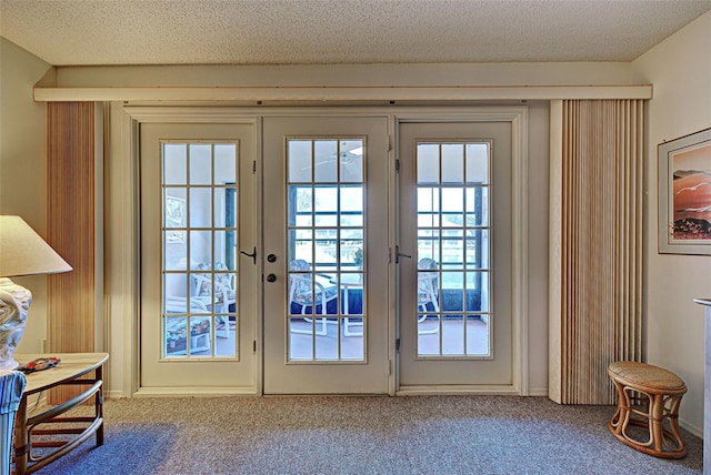 doorway with carpet floors, a textured ceiling, and french doors