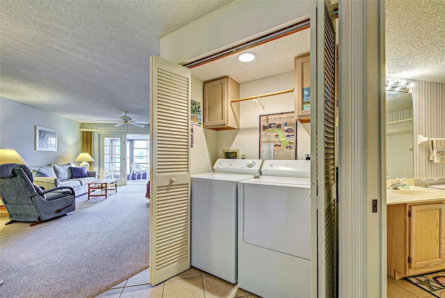 clothes washing area with cabinet space, light carpet, ceiling fan, a textured ceiling, and independent washer and dryer