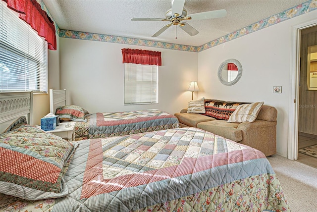 bedroom with a textured ceiling, carpet floors, and a ceiling fan