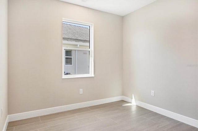 spare room with light wood finished floors and baseboards