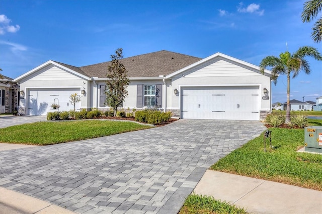 single story home featuring a front lawn, decorative driveway, an attached garage, and stucco siding