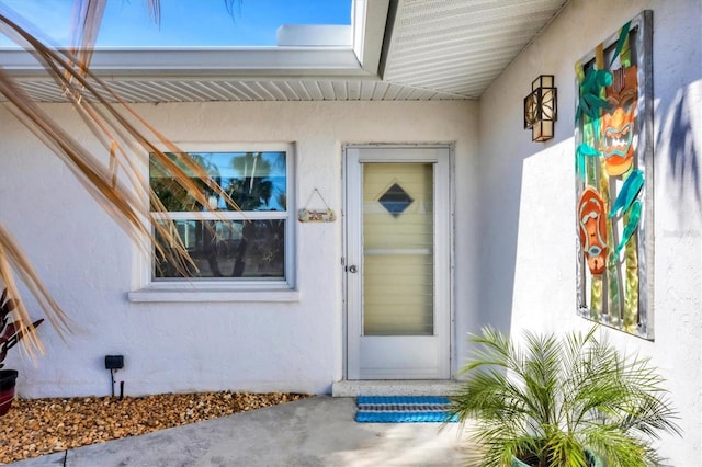 property entrance with stucco siding