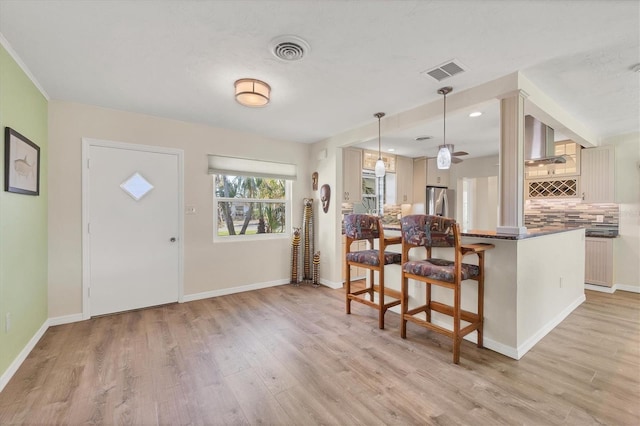 entryway featuring baseboards, visible vents, and light wood finished floors