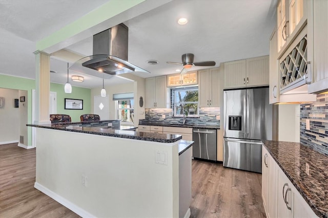 kitchen with stainless steel appliances, pendant lighting, island exhaust hood, and dark wood-style floors