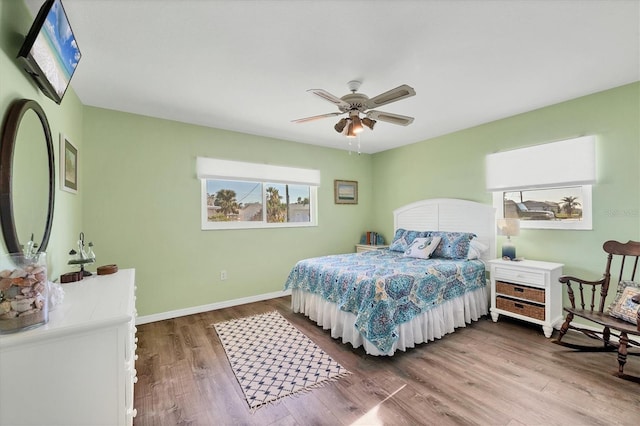 bedroom featuring wood finished floors, a ceiling fan, and baseboards