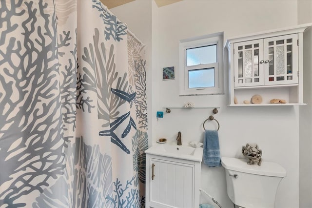 full bath featuring a shower with shower curtain, vanity, and toilet