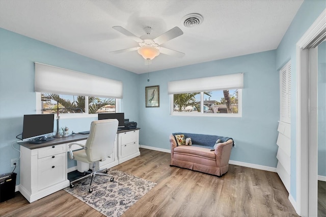 home office featuring light wood-style floors, baseboards, and visible vents