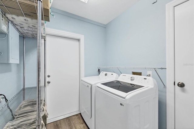 clothes washing area with dark wood-style floors, laundry area, and washing machine and clothes dryer