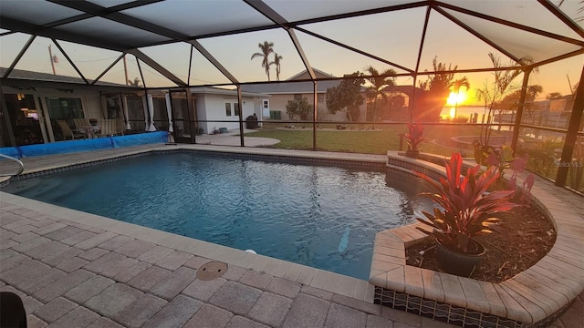 outdoor pool with glass enclosure and a patio area