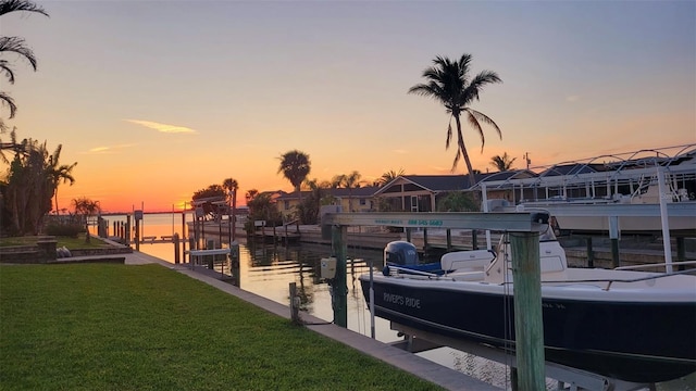 view of dock featuring a lawn and a water view