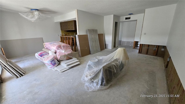 bedroom with a textured ceiling and concrete floors