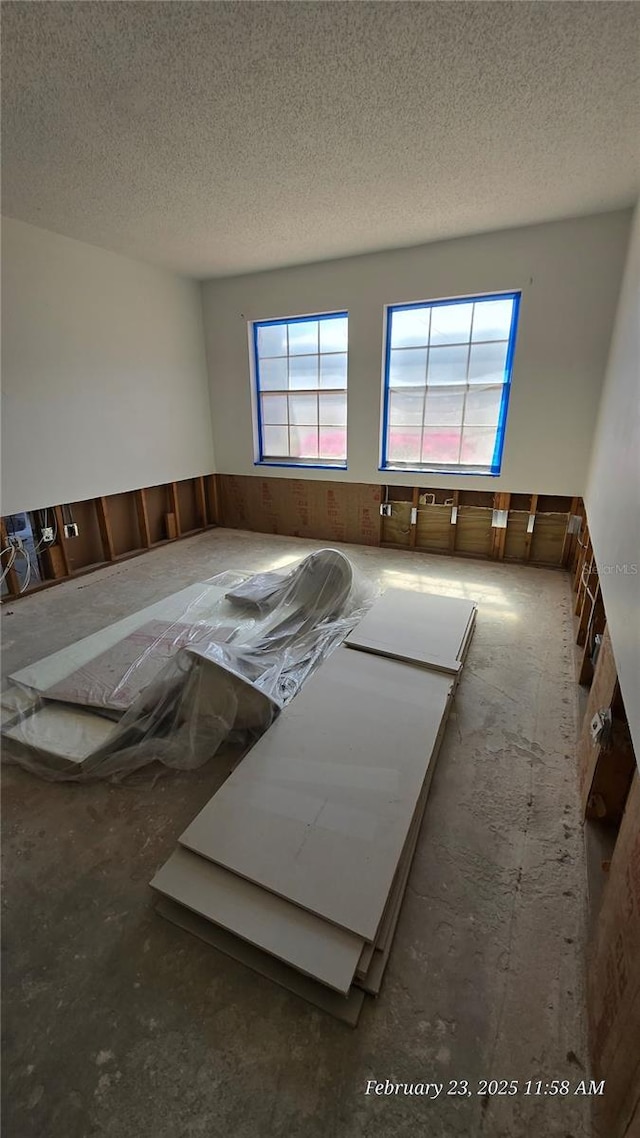 empty room featuring a wainscoted wall and a textured ceiling