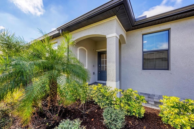 entrance to property featuring stucco siding