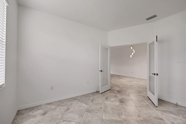 unfurnished room with french doors, visible vents, and baseboards