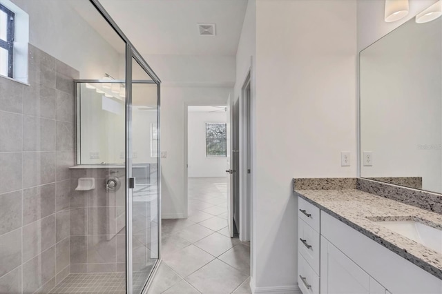 bathroom featuring a stall shower, visible vents, baseboards, tile patterned flooring, and vanity