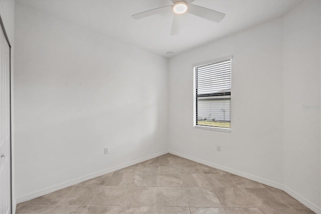 spare room with ceiling fan and baseboards