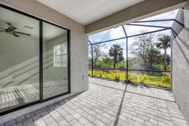 unfurnished sunroom with visible vents and a ceiling fan