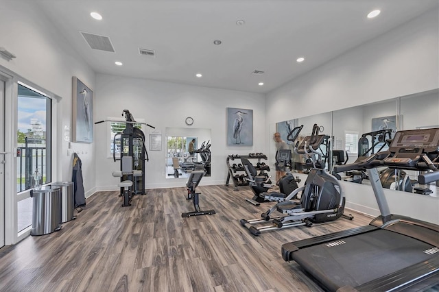 gym with a wealth of natural light, wood finished floors, and visible vents