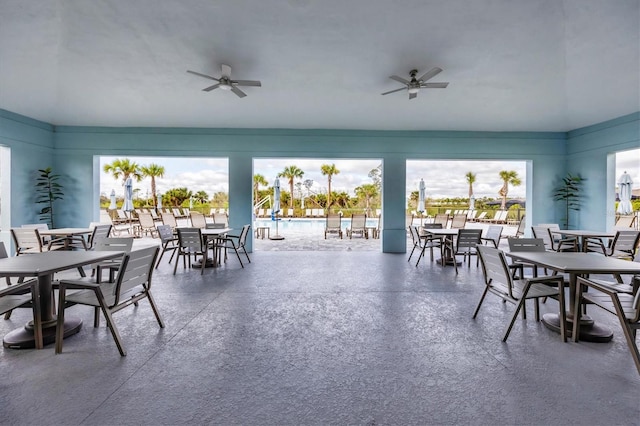 view of patio / terrace with outdoor dining area, a ceiling fan, and a community pool