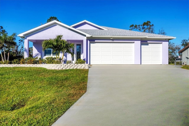 ranch-style house featuring an attached garage, a front yard, concrete driveway, and stucco siding