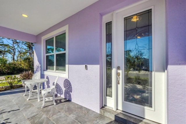 property entrance with a patio and stucco siding