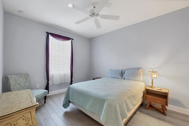 bedroom with ceiling fan, light wood-type flooring, and baseboards