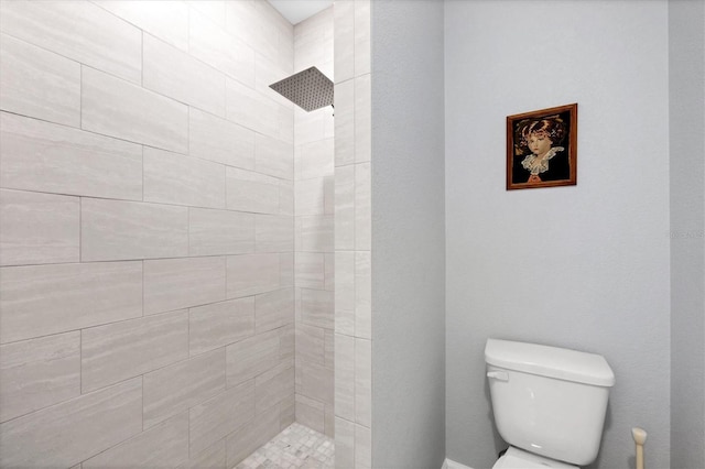 bathroom with tiled shower and toilet