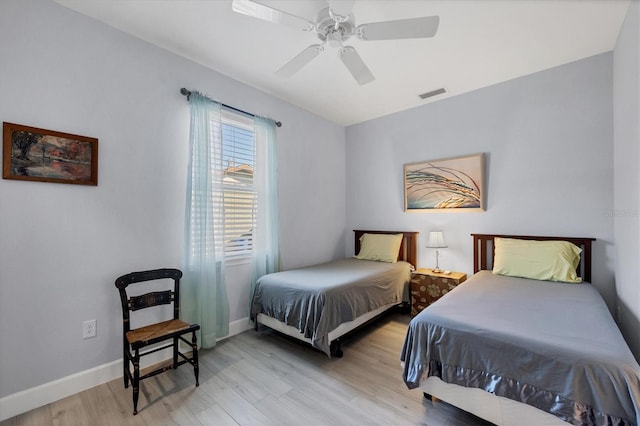 bedroom featuring a ceiling fan, baseboards, visible vents, and light wood finished floors