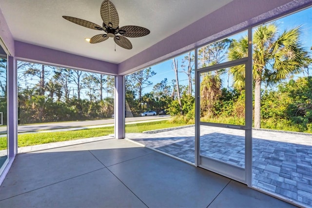 unfurnished sunroom with a ceiling fan