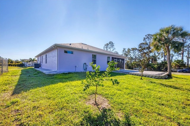 back of house with a lawn and stucco siding