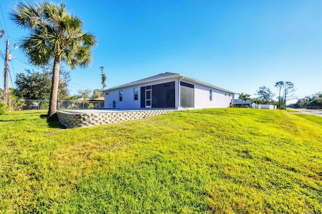 rear view of house with a sunroom and a yard