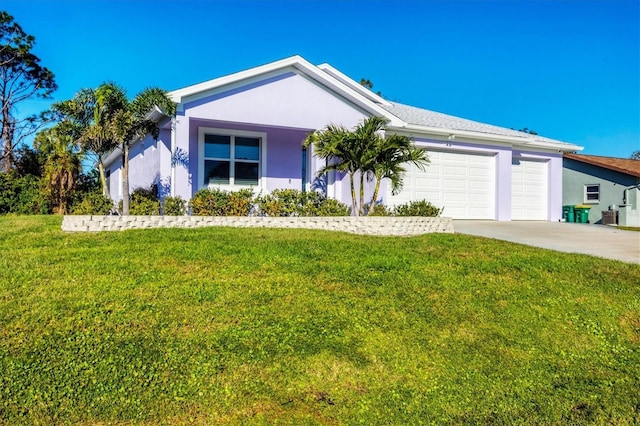 ranch-style home with a garage, a front yard, driveway, and stucco siding