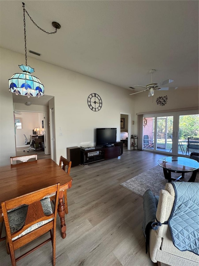 living area with wood finished floors, visible vents, and a ceiling fan