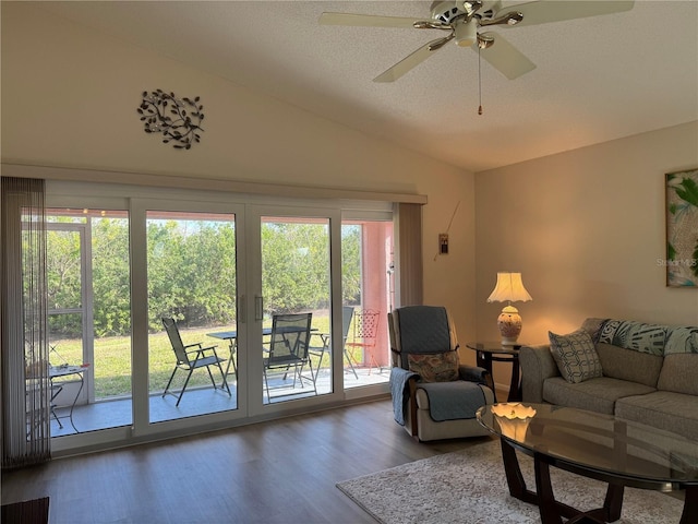 living room featuring ceiling fan, vaulted ceiling, a textured ceiling, and wood finished floors