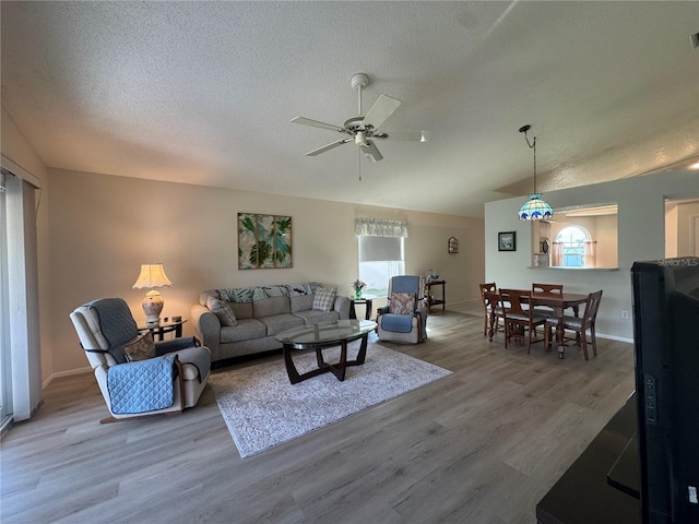 living room featuring lofted ceiling, a textured ceiling, a wealth of natural light, and wood finished floors