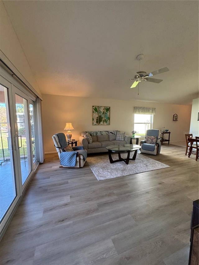 living area featuring light wood-style floors and a ceiling fan