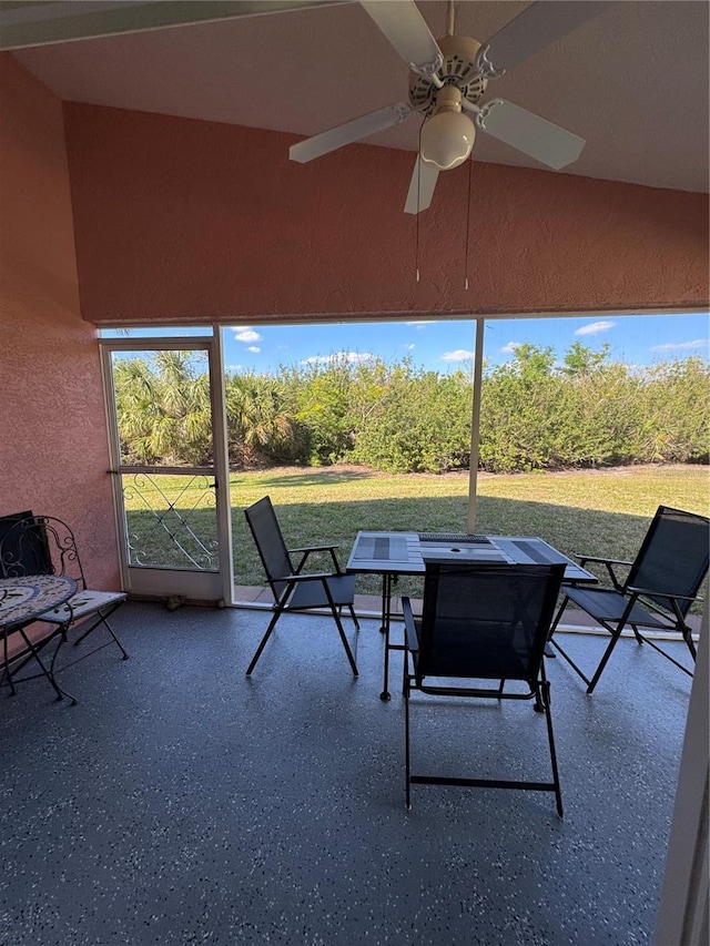 unfurnished sunroom featuring a ceiling fan