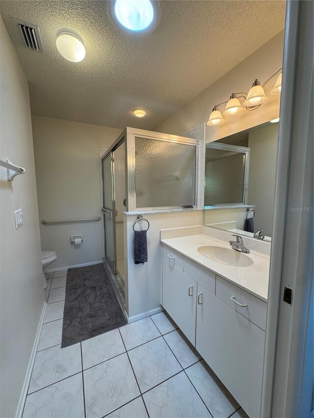 bathroom with visible vents, toilet, a textured ceiling, vanity, and a shower stall