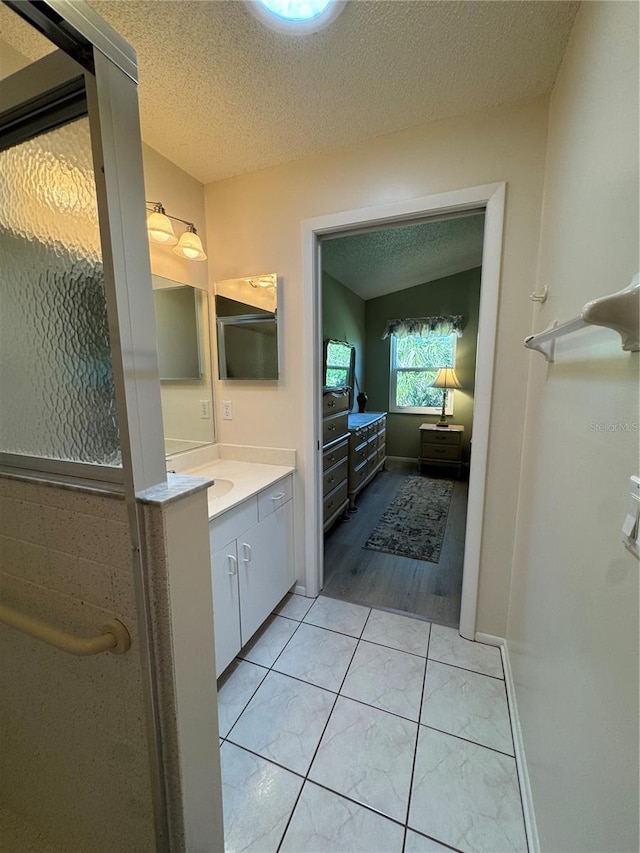 bathroom with a textured ceiling, vanity, and tile patterned floors